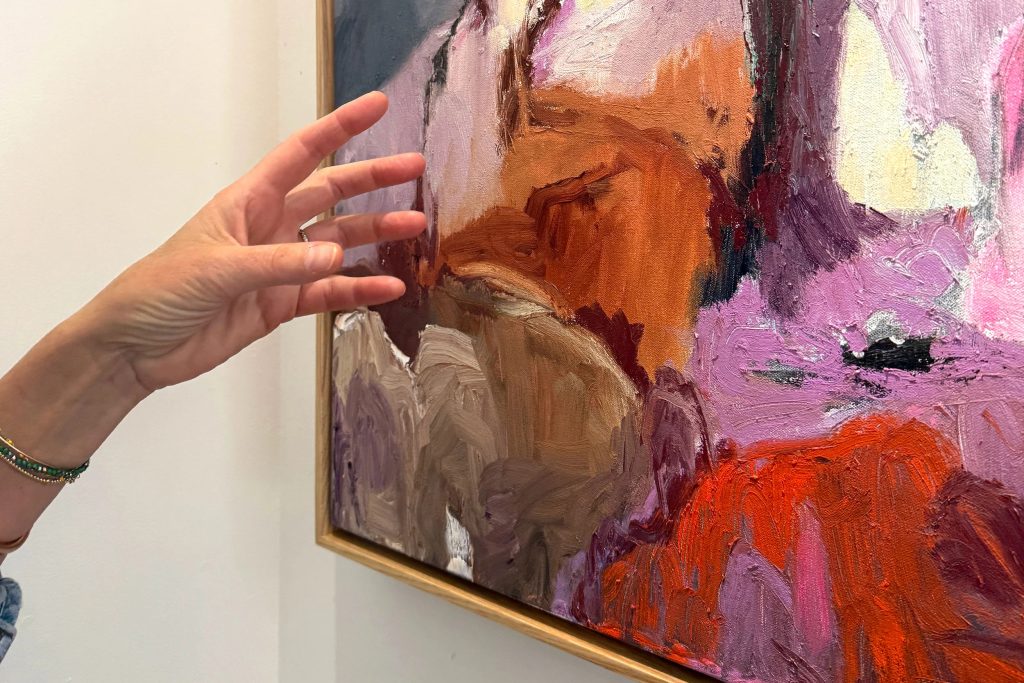 Artist Kara McIntosh with one of her paintings in her studio.